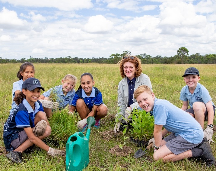 School kids planing trees with Execuive Director Suellen Fitzgerald