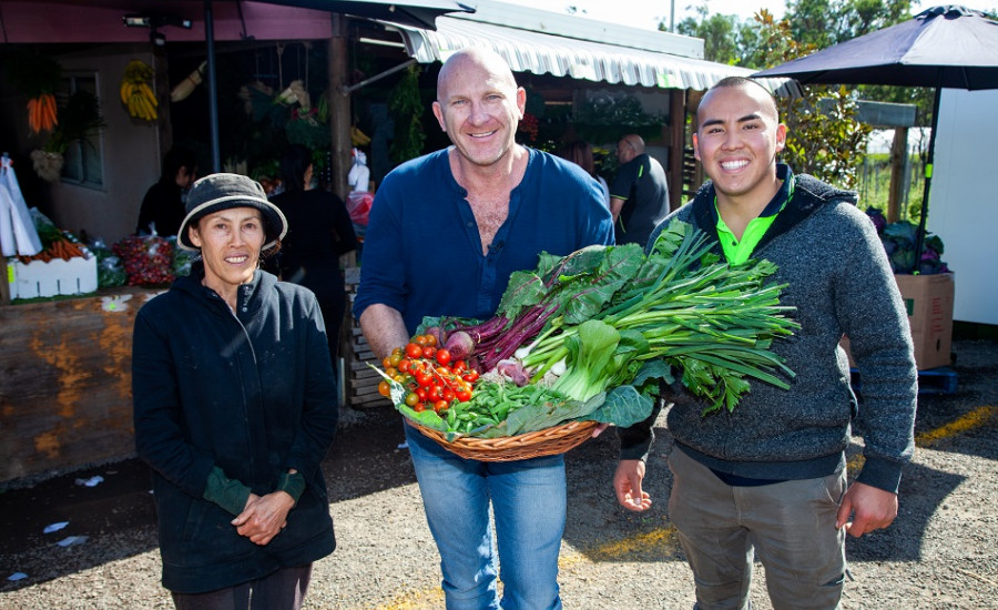 Matt Moran holding a basket of Mrs Sun's veggies take from Western Sydney Parklands Urban Farms