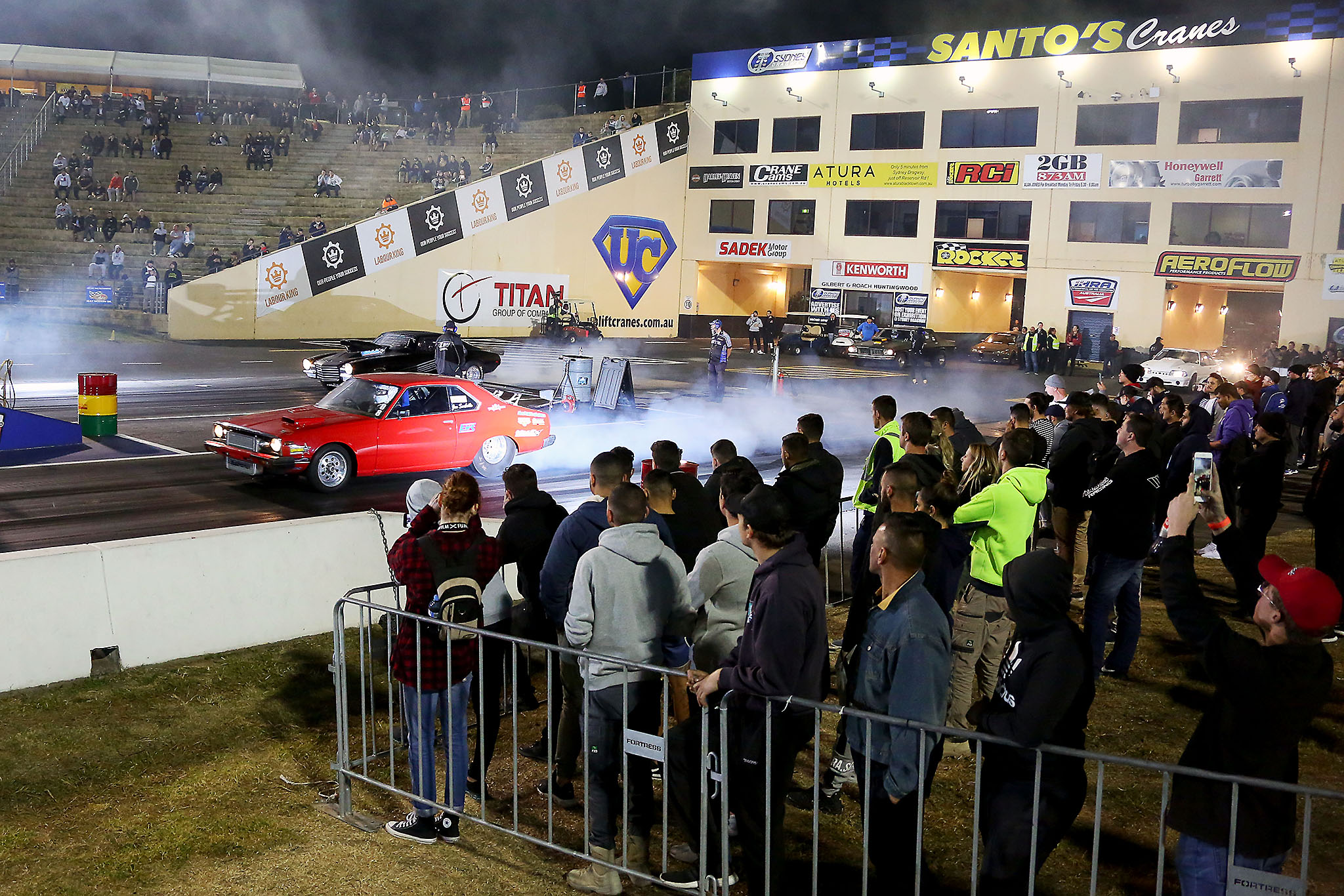 Sydney dragway races red and black car with crow of people