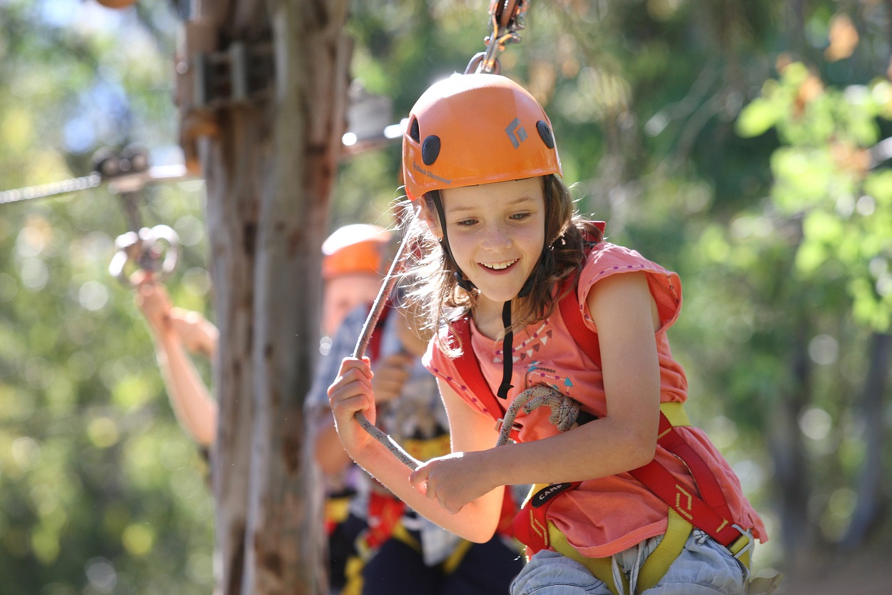 girl walking on ropes course in the tree tops